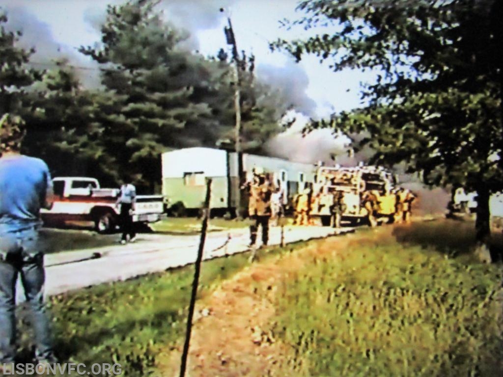 Chief Bowman has taken about 10 steps from the previus photo, E-41 personnel are preparing themselves for the &quot;attack&quot;, when suddenly there was an EXPLOSION (propane, acetylene, gasoline is unknown). You can see the force of the explosion with smoke and debris being expelled laterally from Left to Right. (Note that the barn that was on fire was being utilized as a maintenance/repair shed with all tools/fuels/equipment/chemicals one would expect in such a structure. To complicate matters, the fire building had immediate/pending exposures on all 4 sides. 2 barns, a trailer and a farm house) It should also be noted, which can be seen in the video, NONE of E-41's personnel were aware that an explosion had occurred since they were focused on the immediate task at hand.